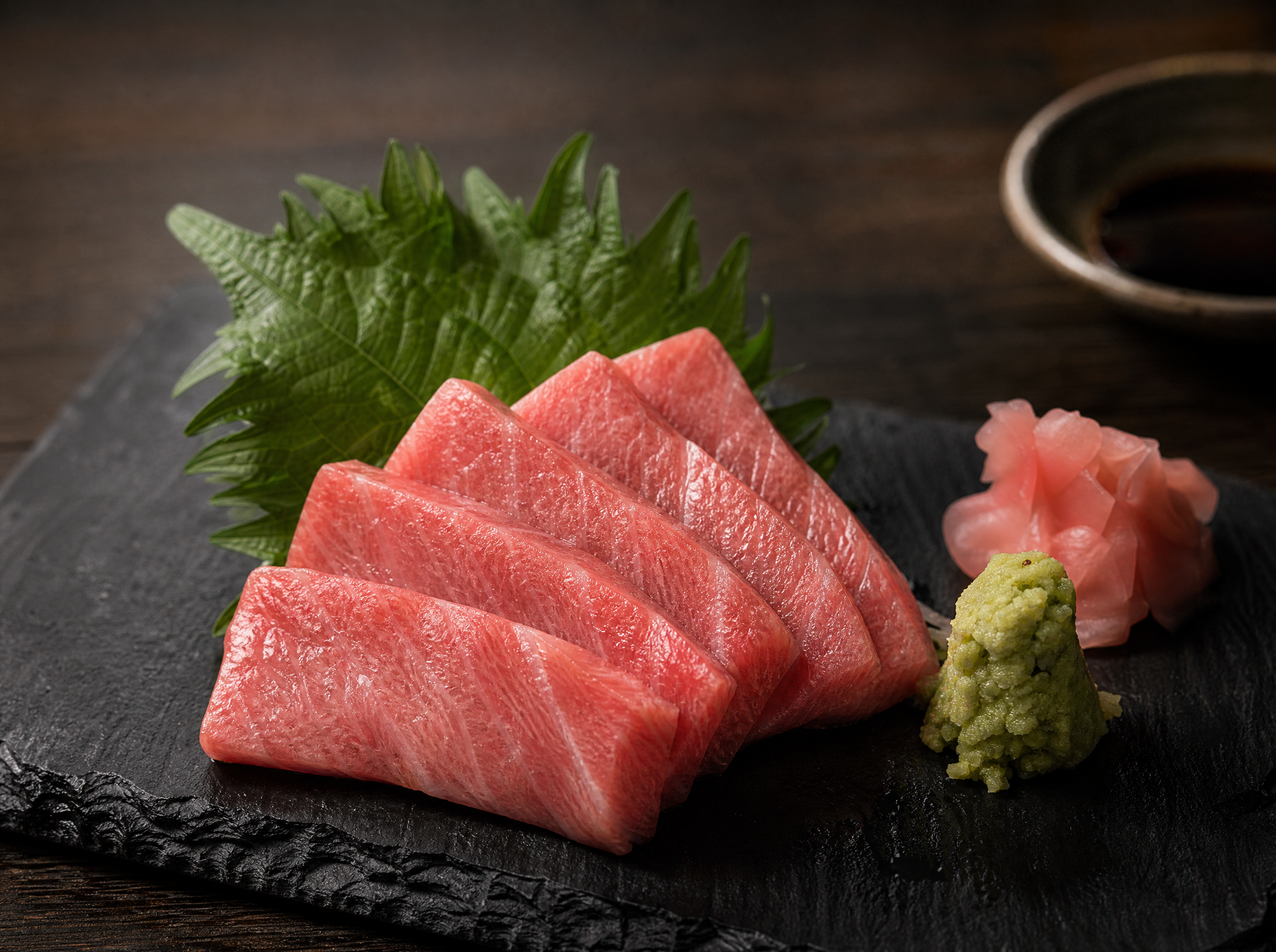 Chutoro sashimi on dark slate plate with wasabi and garnish