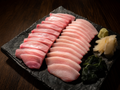 Premium yellowtail hamachi sashimi set with belly and loin cuts, gamtae seaweed, wasabi and pickled ginger on dark slate