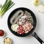 Nakgopdaesae raw ingredients arranged in a pan before cooking